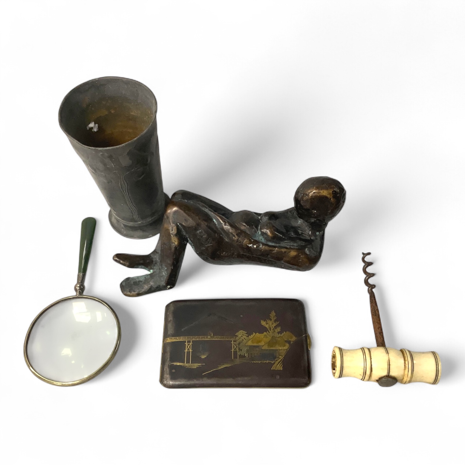A Japanese damascened iron cigarette case, early 20th century, an indistinctly signed abstract figural reclining bronze, a bone handled corkscrew, an Orivit pewter vessel and a silver mounted magnifying glass